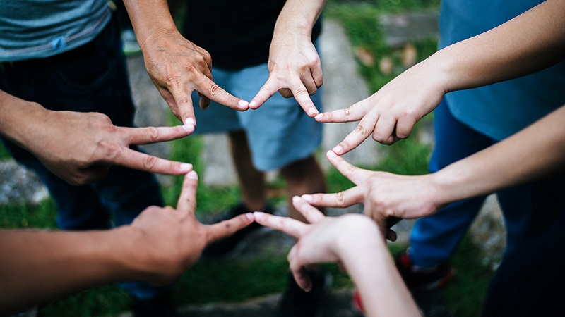 Women and men friends make star shape from fingers. Success, fri